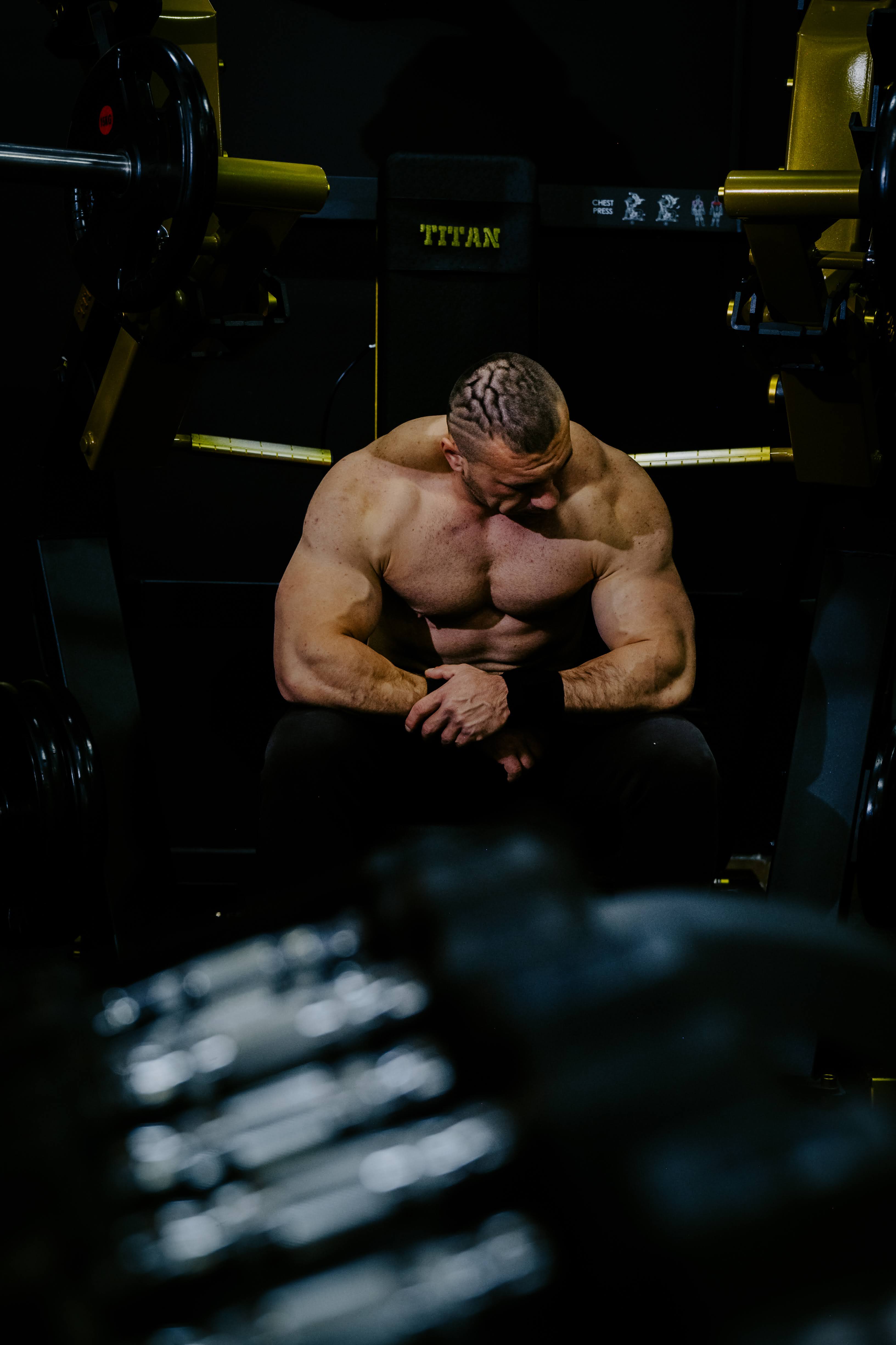Athlet im dunklen Gym bei schwerem Zug Training